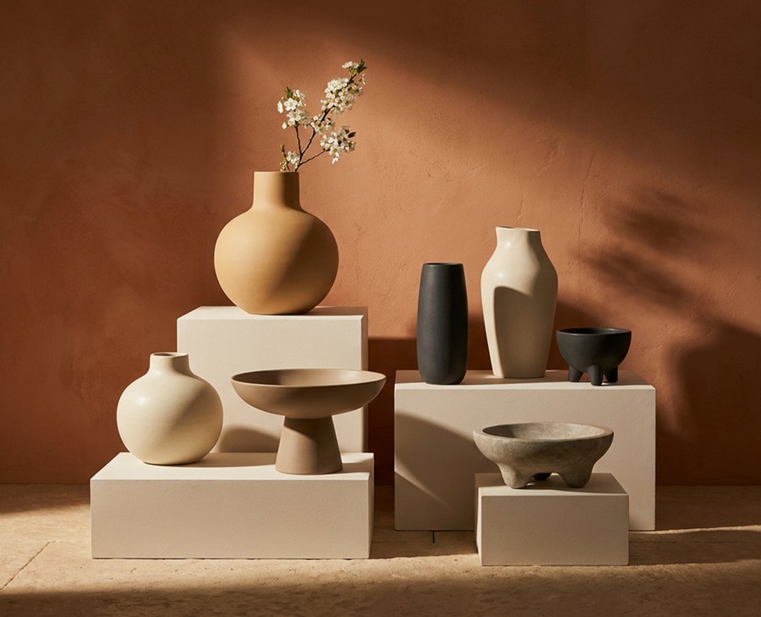 Sculptural ceramic vessels arranged in warm sunlight